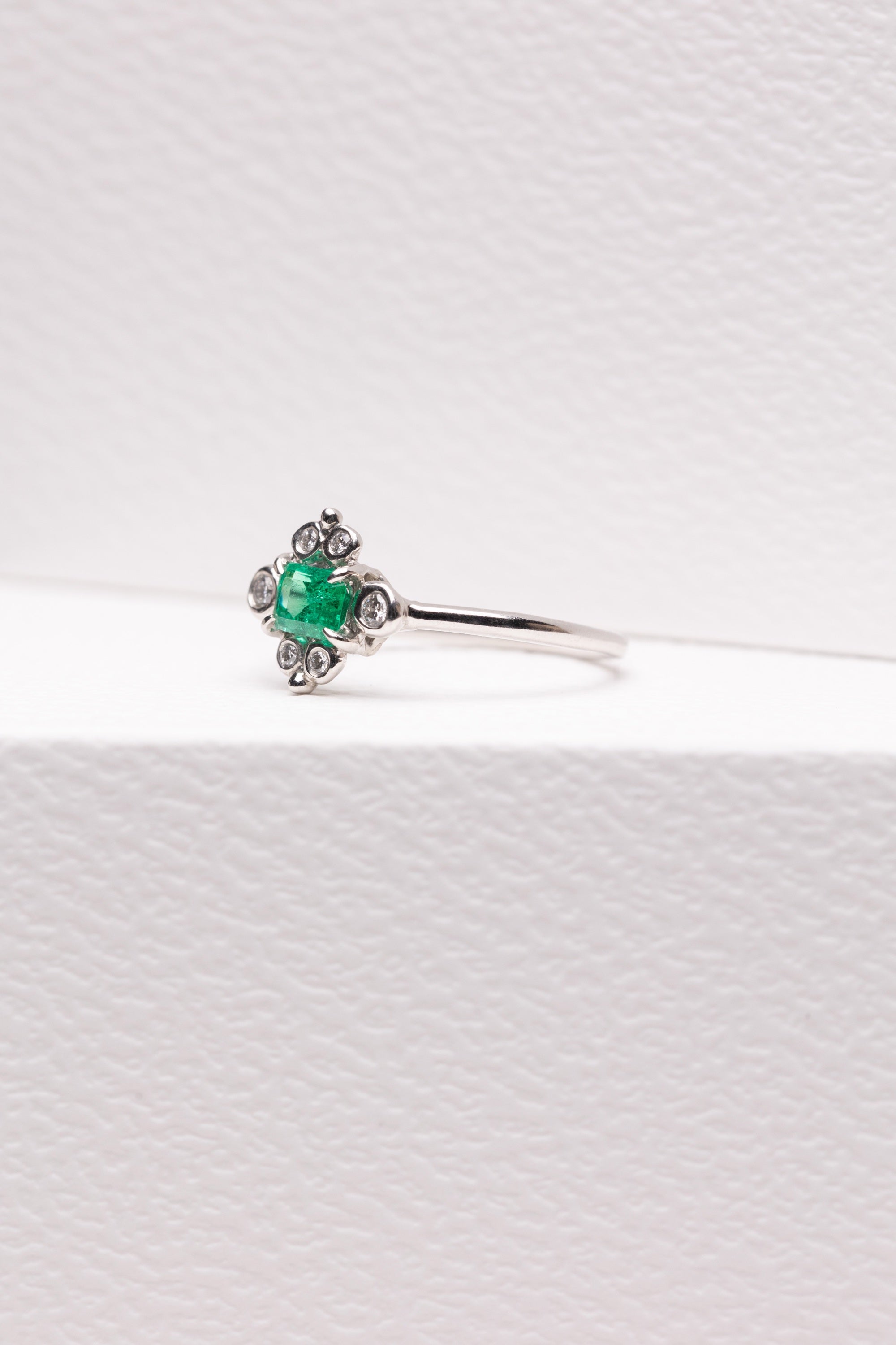 Bright Emerald Platinum Ring Surrounded by White Diamonds