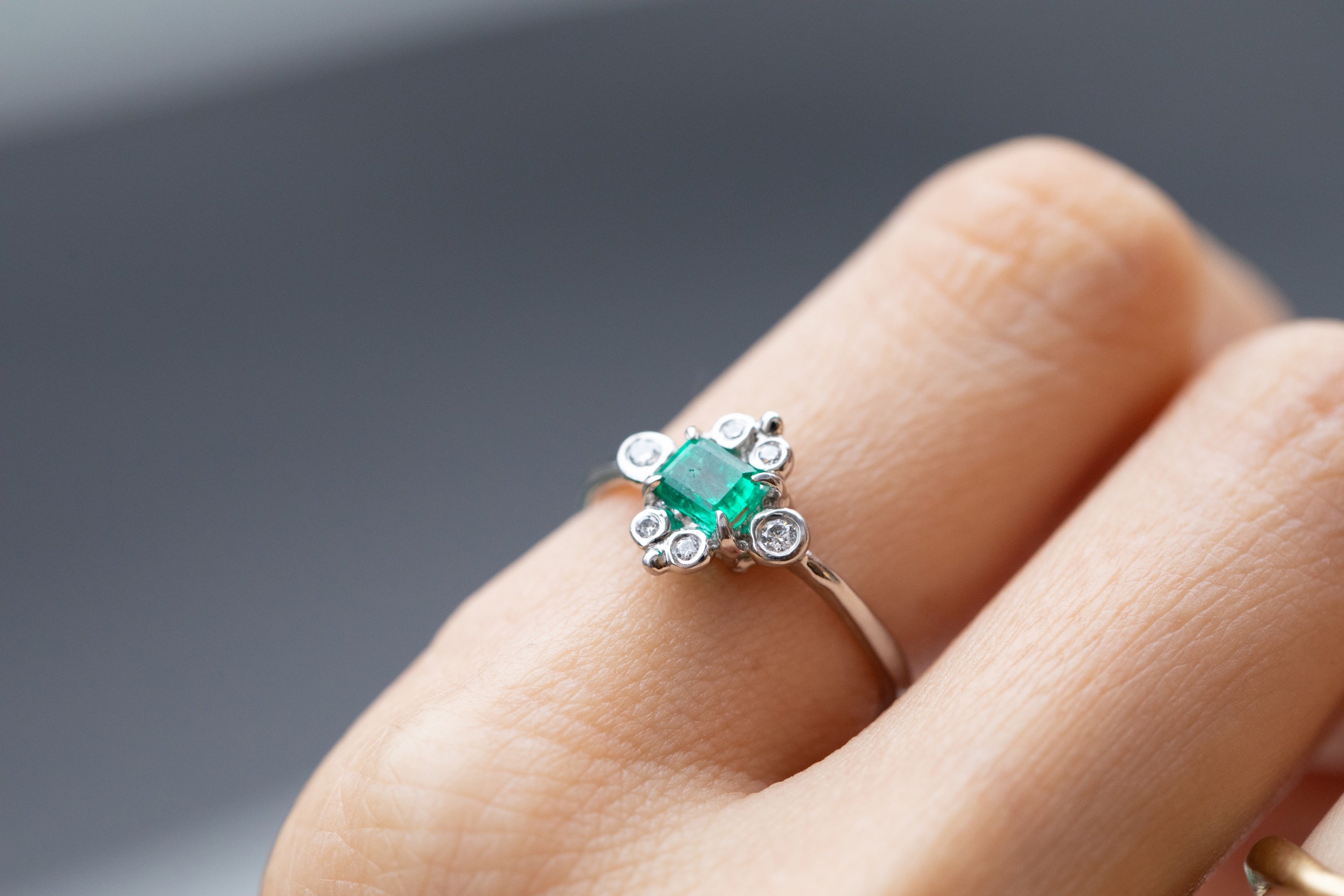 Bright Emerald Platinum Ring Surrounded by White Diamonds